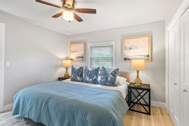 bedroom featuring light wood-type flooring, ceiling fan, and a closet