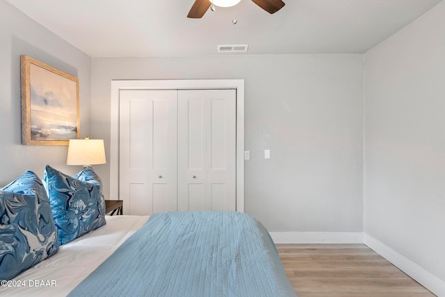 bedroom featuring light hardwood / wood-style floors, ceiling fan, and a closet