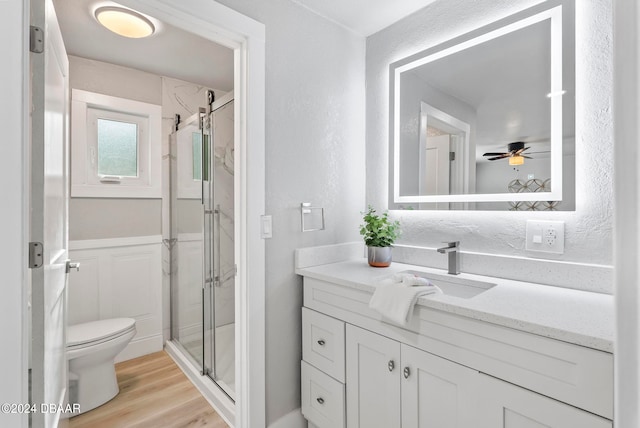 bathroom featuring ceiling fan, wood-type flooring, vanity, and an enclosed shower