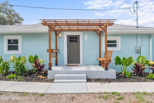 doorway to property featuring a pergola