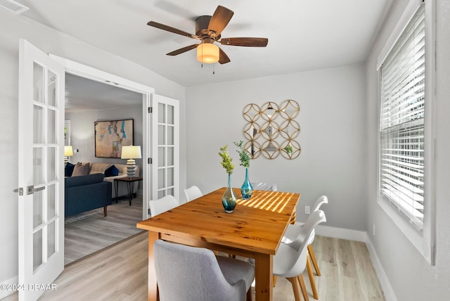 dining space with light wood-type flooring, french doors, and ceiling fan