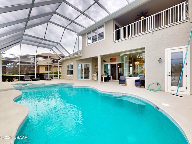 view of pool with ceiling fan, outdoor lounge area, a patio, glass enclosure, and a pool with connected hot tub