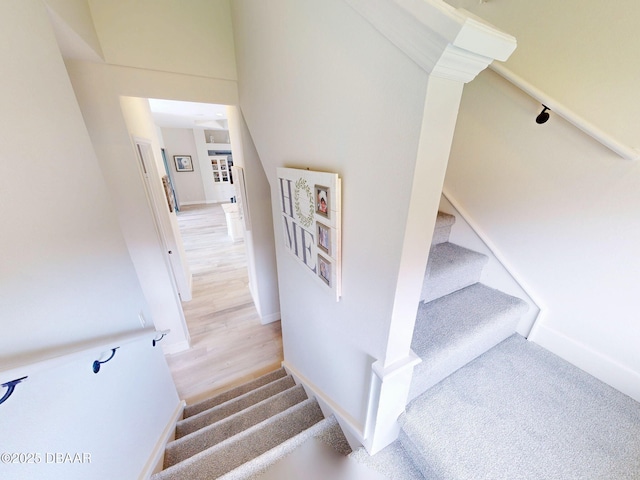 stairway featuring baseboards and wood finished floors