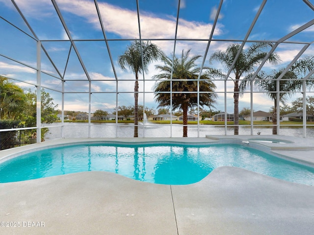 view of pool with a patio, glass enclosure, and a pool with connected hot tub