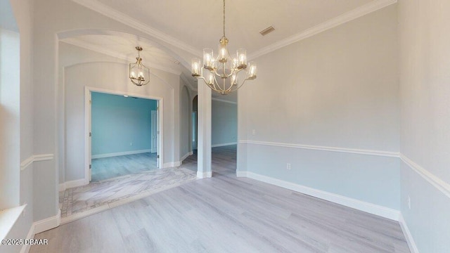 spare room with crown molding, a chandelier, and light hardwood / wood-style flooring