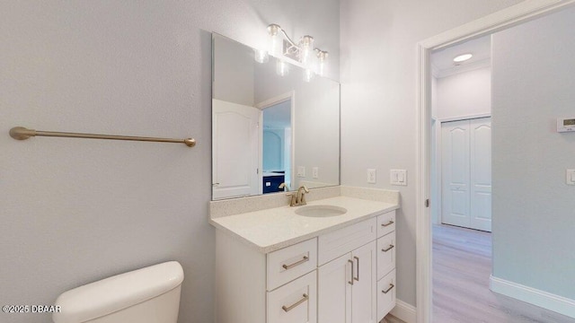 bathroom with hardwood / wood-style flooring, vanity, and toilet