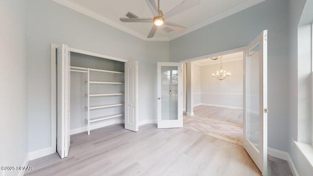 unfurnished bedroom with crown molding, light hardwood / wood-style floors, french doors, ceiling fan with notable chandelier, and a closet