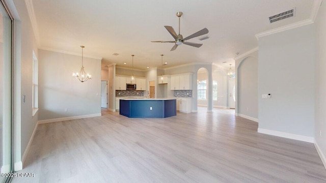 unfurnished living room featuring crown molding, ceiling fan with notable chandelier, and light hardwood / wood-style floors