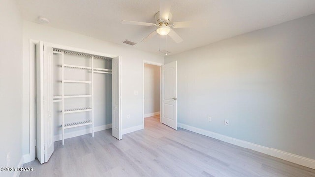 unfurnished bedroom with light hardwood / wood-style floors, ceiling fan, and a closet