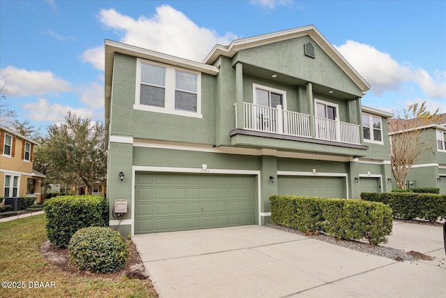 multi unit property with a garage, a balcony, and central AC