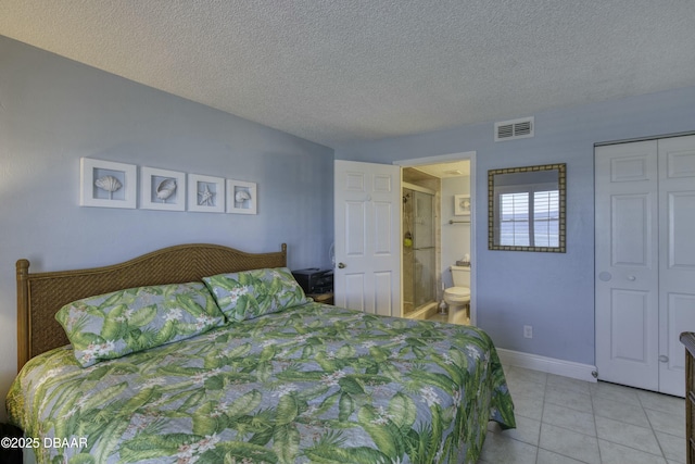 bedroom featuring a textured ceiling, a closet, light tile patterned floors, and connected bathroom