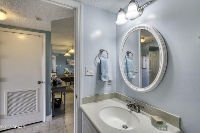 bathroom featuring a textured ceiling, tile patterned floors, and vanity