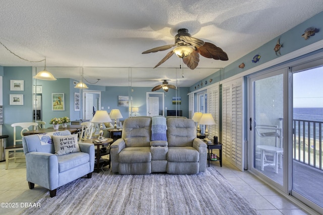 living room featuring a textured ceiling, light tile patterned floors, and a water view