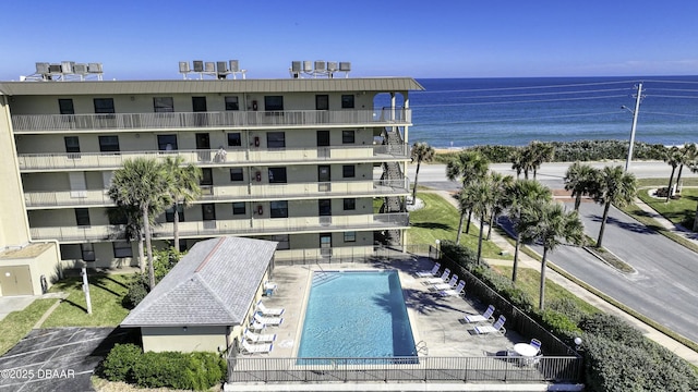 view of pool featuring a water view and a patio