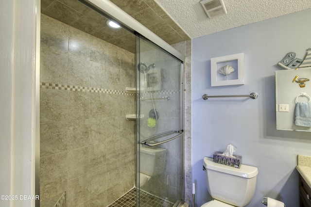 bathroom featuring walk in shower, vanity, toilet, and a textured ceiling