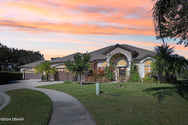 view of front of property with a lawn and a garage