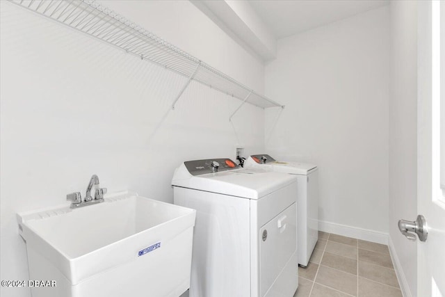 laundry room featuring washer and dryer, light tile patterned floors, and sink