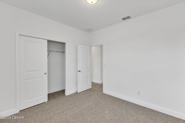 unfurnished bedroom featuring carpet and a closet