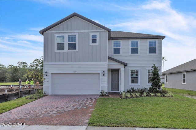 view of front of property with a front yard and a garage