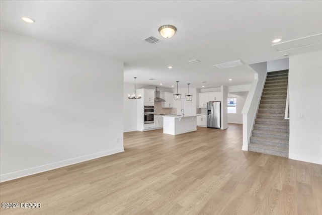 unfurnished living room with sink and light wood-type flooring