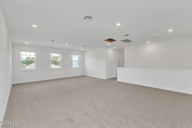 spare room featuring light colored carpet