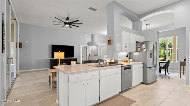 kitchen with stainless steel appliances, a peninsula, a sink, visible vents, and light countertops