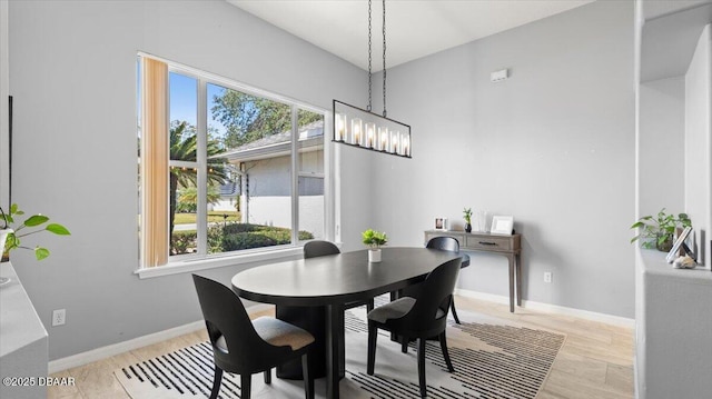 dining area with a healthy amount of sunlight, baseboards, a chandelier, and wood finished floors