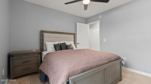 bedroom featuring ceiling fan, light wood-style flooring, and baseboards