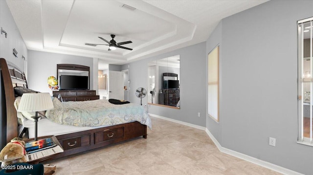 bedroom featuring a ceiling fan, a raised ceiling, visible vents, and baseboards