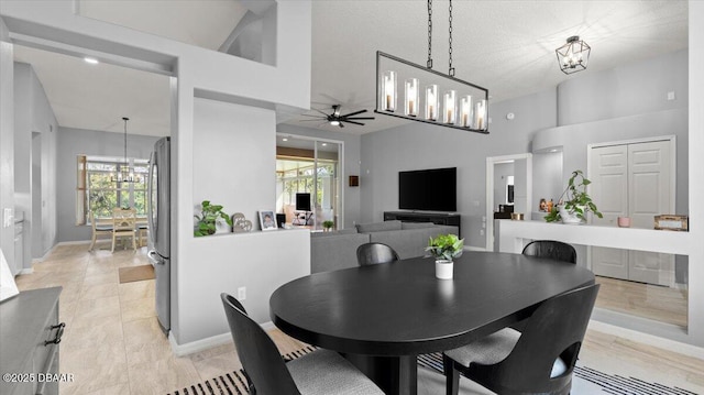 dining area featuring ceiling fan with notable chandelier and baseboards