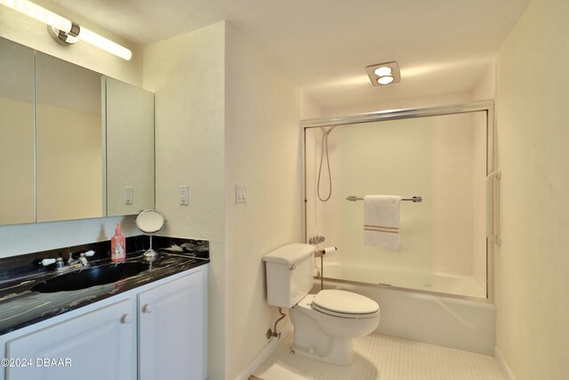 3047 S Atlantic Ave Unit 1206, Daytona Beach, FL 32118 - full bathroom featuring bath / shower combo with glass door, vanity, tile patterned floors, and toilet