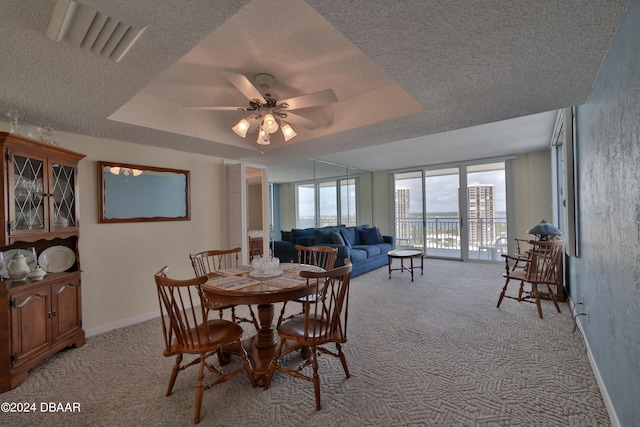 3047 S Atlantic Ave Unit 1206, Daytona Beach, FL 32118 - dining room featuring ceiling fan, a textured ceiling, light carpet, and a raised ceiling