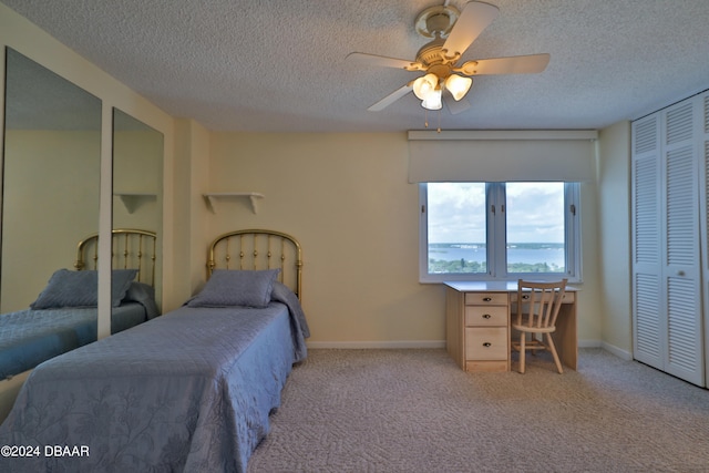 3047 S Atlantic Ave Unit 1206, Daytona Beach, FL 32118 - bedroom featuring a closet, a textured ceiling, light carpet, and ceiling fan