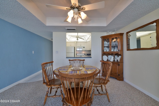 3047 S Atlantic Ave Unit 1206, Daytona Beach, FL 32118 - dining space featuring a textured ceiling, light carpet, ceiling fan, and a raised ceiling