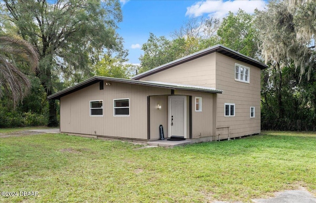 rear view of house featuring a yard