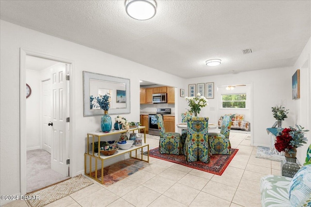 living room with a textured ceiling and light tile patterned floors