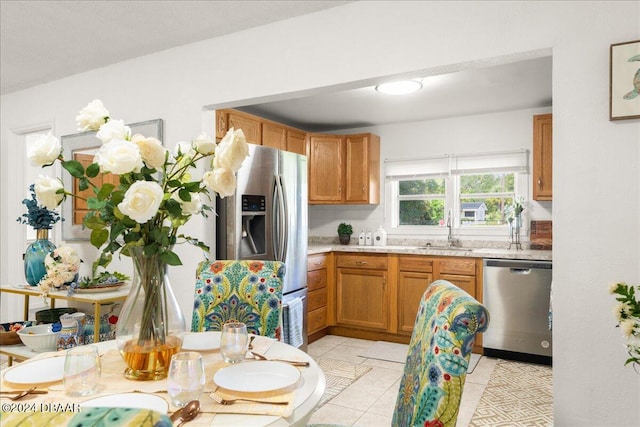 kitchen with tasteful backsplash, appliances with stainless steel finishes, sink, and light tile patterned flooring