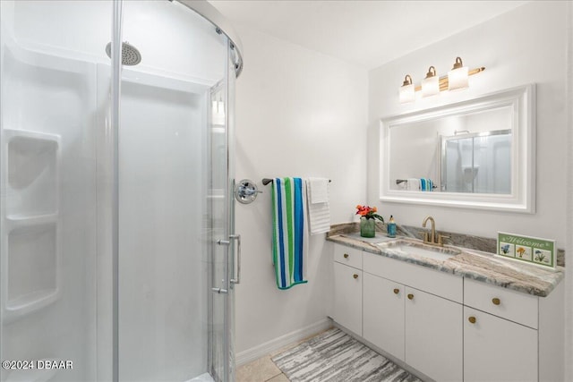 bathroom featuring tile patterned flooring, vanity, and a shower with door