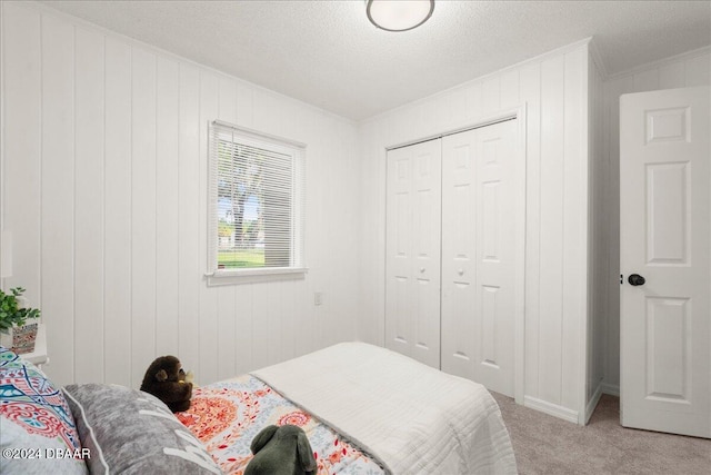 carpeted bedroom featuring a closet, a textured ceiling, and wood walls