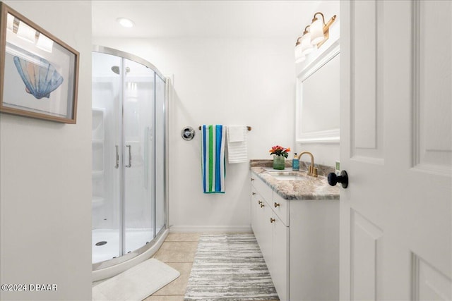 bathroom with vanity, a shower with shower door, and tile patterned floors