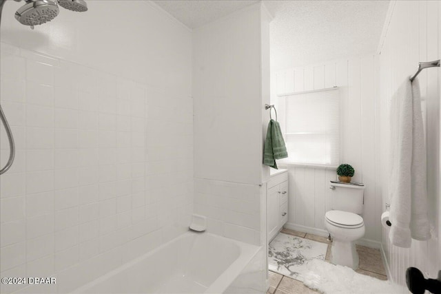 full bathroom featuring vanity, a textured ceiling, wood walls, tiled shower / bath combo, and toilet