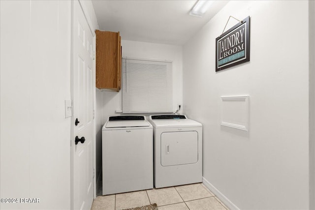 washroom with cabinets, washer and dryer, and light tile patterned floors