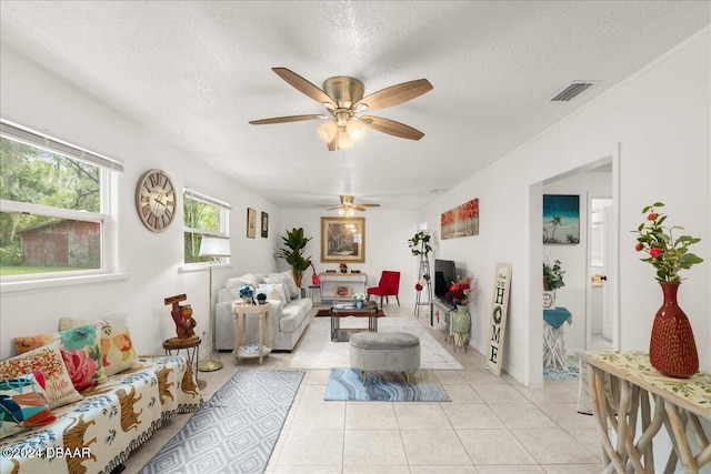 tiled living room featuring a textured ceiling and ceiling fan