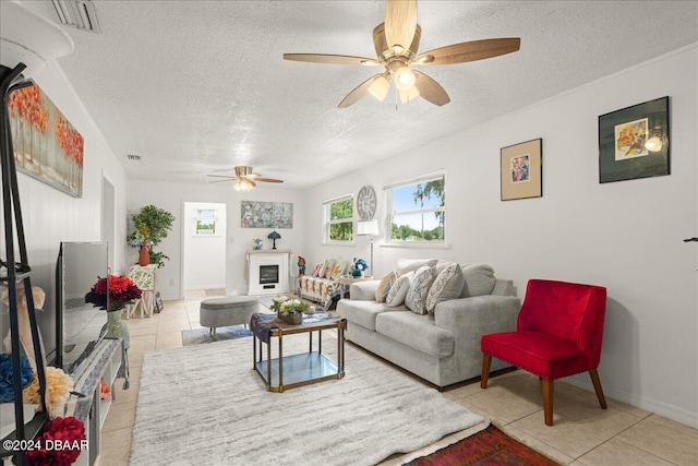 tiled living room with a textured ceiling and ceiling fan