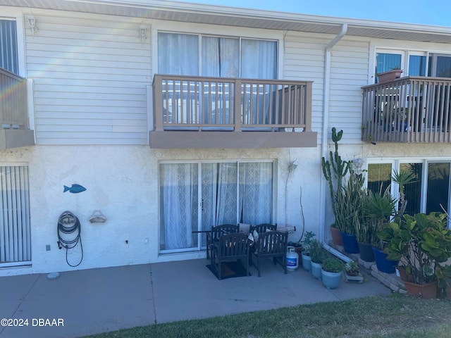 back of property with a balcony and a patio area