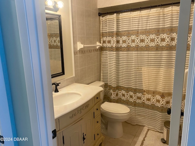 bathroom with toilet, tile patterned floors, tile walls, curtained shower, and vanity