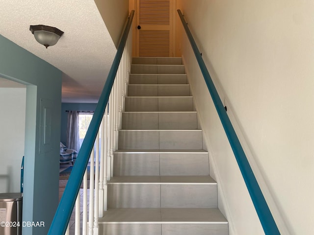 stairs featuring a textured ceiling and tile patterned floors