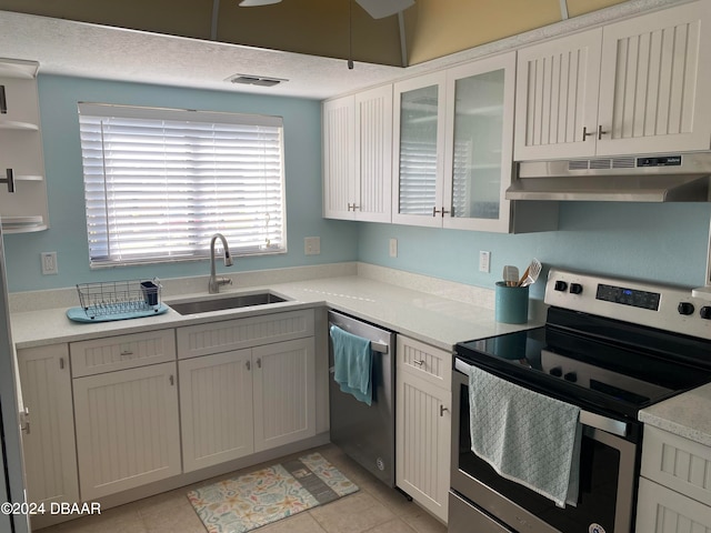 kitchen featuring white cabinetry, appliances with stainless steel finishes, sink, and light tile patterned floors