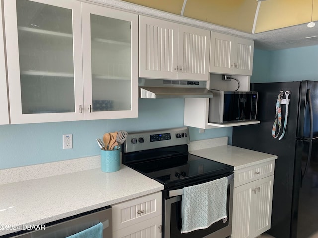 kitchen featuring white cabinetry, range hood, electric range, and black refrigerator