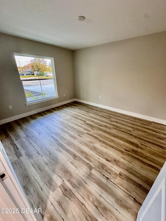 unfurnished room with light wood-style floors and baseboards